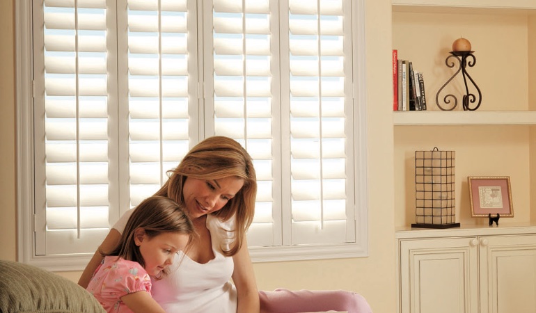 Mom and daughter in front of window